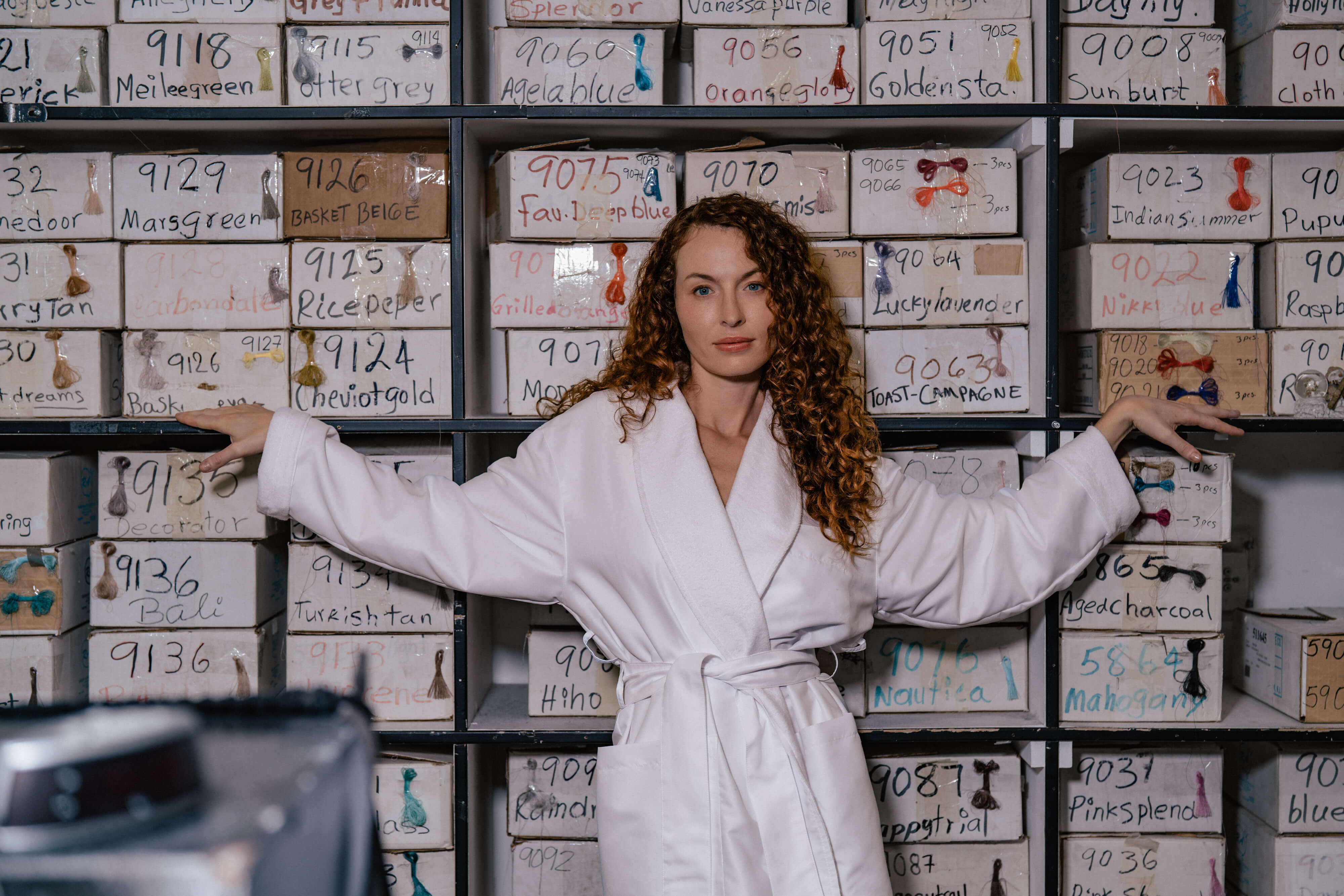girl standing in front of warehouse of thread and colors